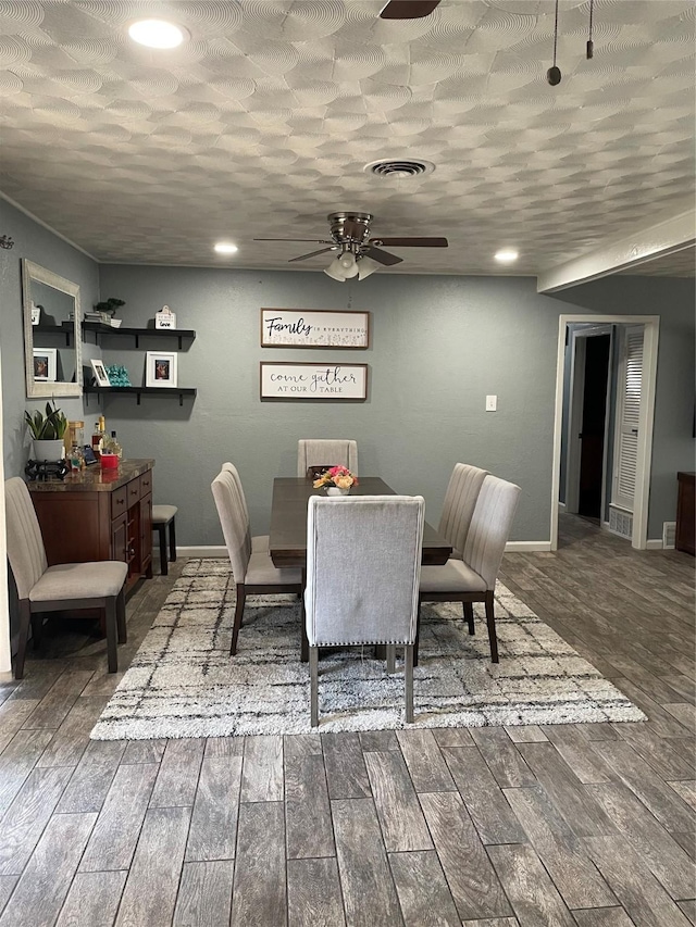 dining room with visible vents, baseboards, wood finished floors, and a ceiling fan