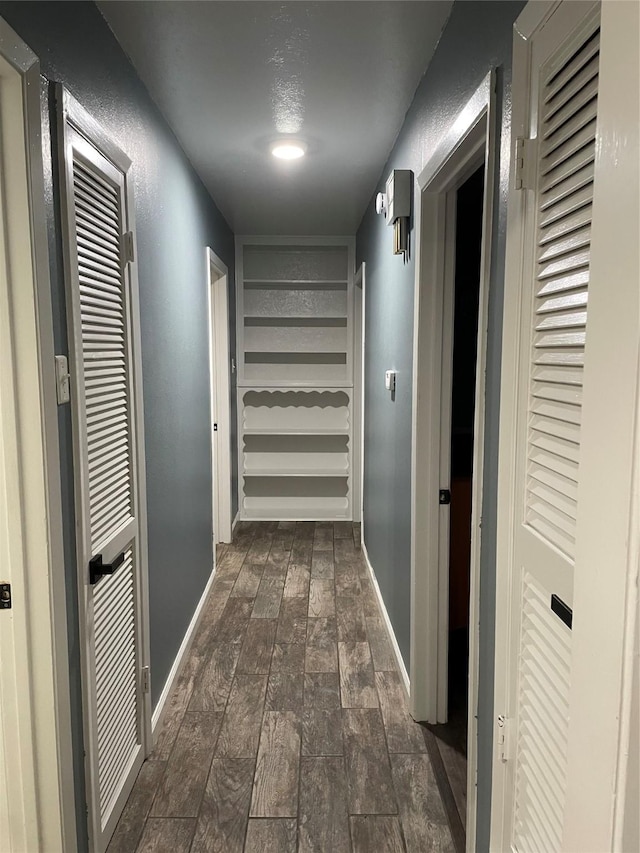 hall with baseboards and wood tiled floor