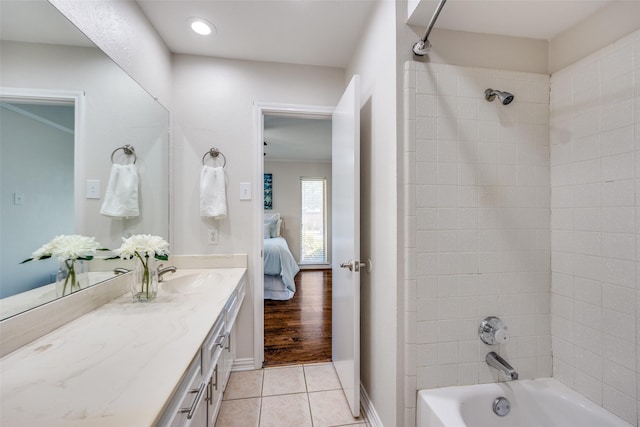 bathroom with connected bathroom, tile patterned flooring, baseboards, bathtub / shower combination, and vanity