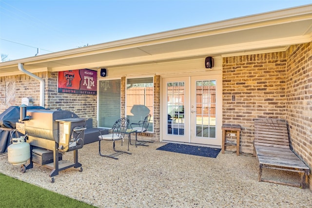 view of exterior entry with brick siding and french doors