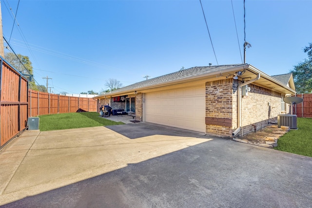 view of side of property featuring brick siding, a garage, and fence