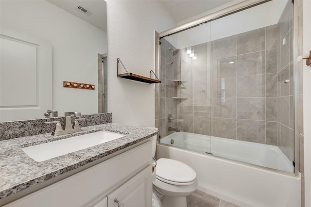 bathroom featuring combined bath / shower with glass door, visible vents, toilet, and vanity