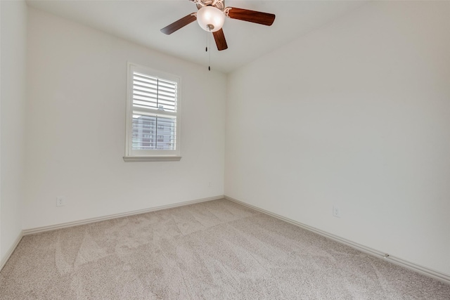 spare room featuring a ceiling fan, baseboards, and light carpet