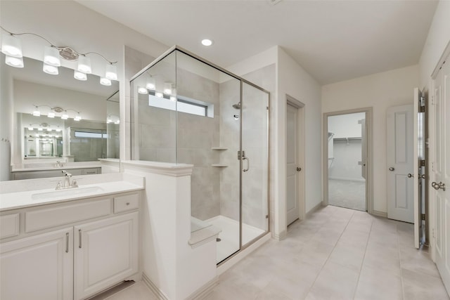 bathroom featuring vanity, a spacious closet, a shower stall, and tile patterned flooring