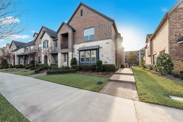 view of front of property with stone siding, a residential view, brick siding, and a front yard