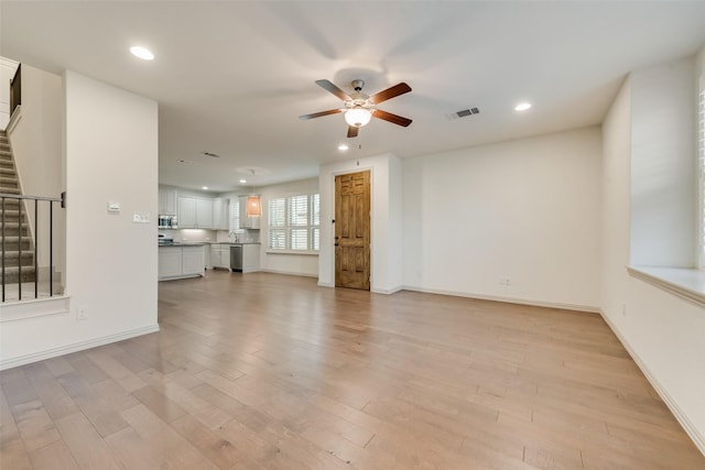 unfurnished living room featuring recessed lighting, stairway, light wood-style flooring, and ceiling fan