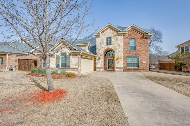 view of front of property featuring driveway, stone siding, fence, an attached garage, and brick siding