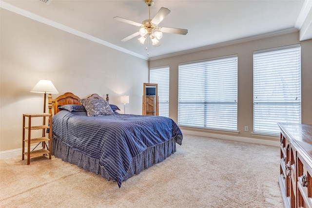 carpeted bedroom featuring baseboards, ceiling fan, and crown molding