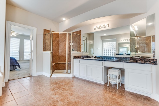 ensuite bathroom with tile patterned floors, a stall shower, vanity, and ensuite bath