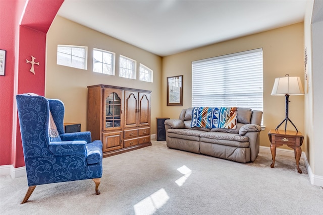 carpeted living area with baseboards