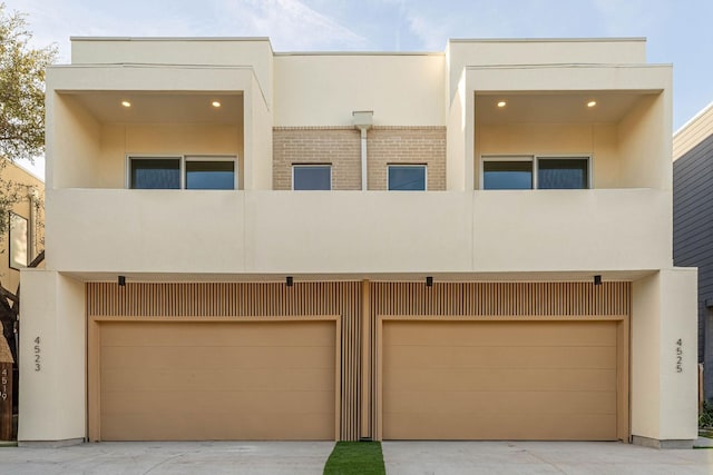 view of front of property with brick siding, stucco siding, and a balcony