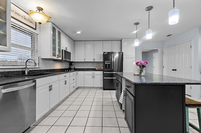 kitchen featuring backsplash, fridge with ice dispenser, stainless steel dishwasher, light tile patterned flooring, and a sink