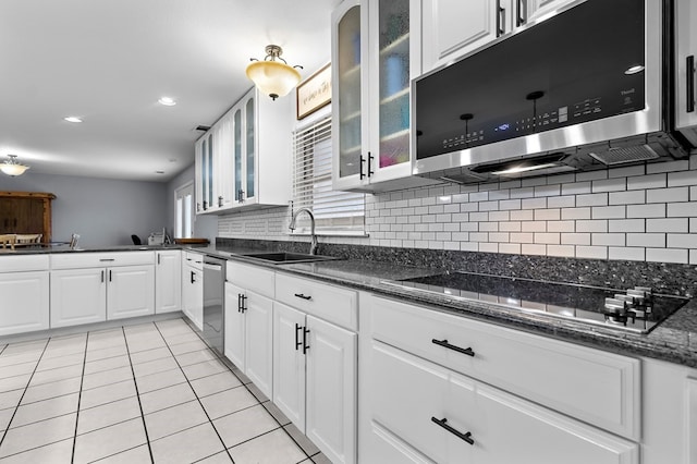 kitchen with light tile patterned floors, a sink, white cabinets, appliances with stainless steel finishes, and backsplash