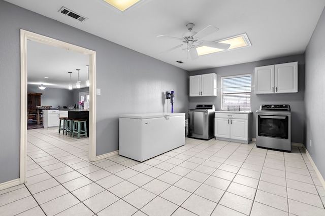 kitchen featuring fridge, light tile patterned floors, range, and visible vents