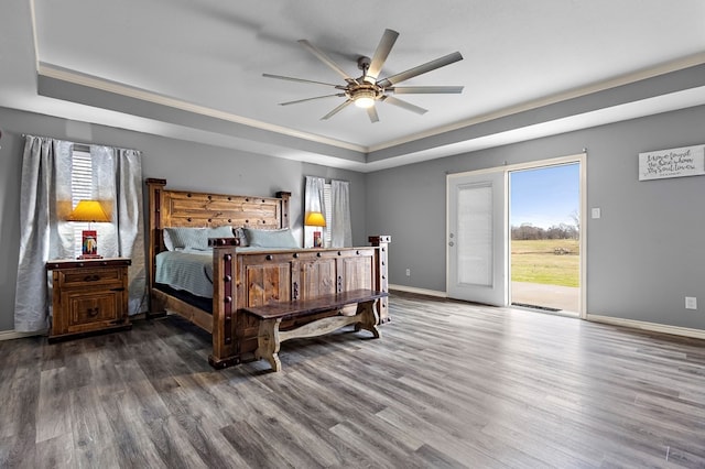 bedroom with a raised ceiling, wood finished floors, access to exterior, and baseboards