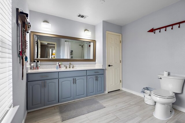 bathroom with vanity, visible vents, baseboards, a stall shower, and toilet