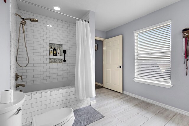 full bath featuring baseboards, toilet, and tiled shower / bath combo