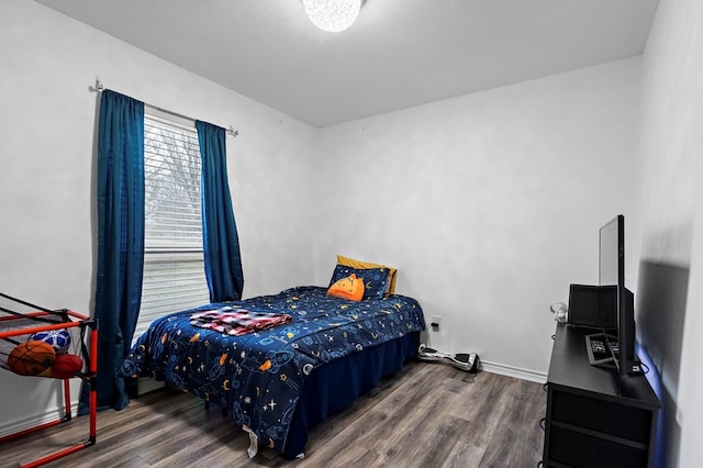 bedroom with baseboards and wood finished floors