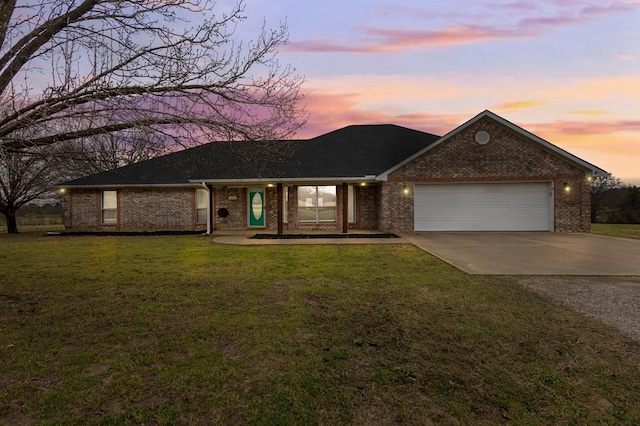 ranch-style house featuring brick siding, an attached garage, concrete driveway, and a front yard