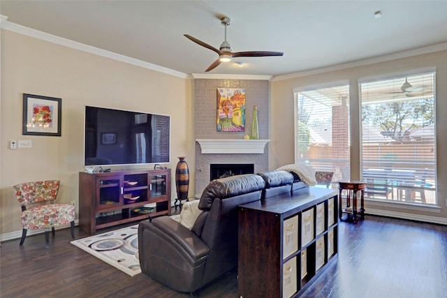 living room featuring wood finished floors, plenty of natural light, a fireplace, and crown molding