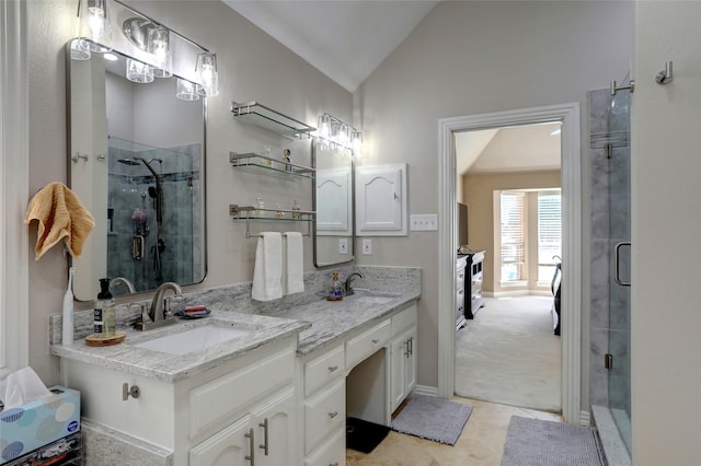 full bathroom with lofted ceiling, double vanity, a shower stall, and a sink