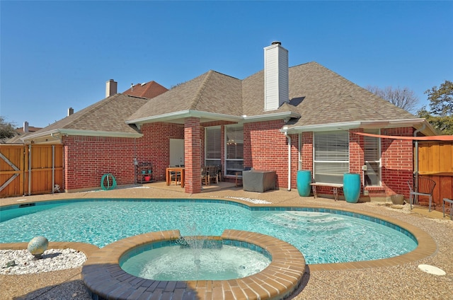 view of swimming pool with a patio, fence, and a pool with connected hot tub