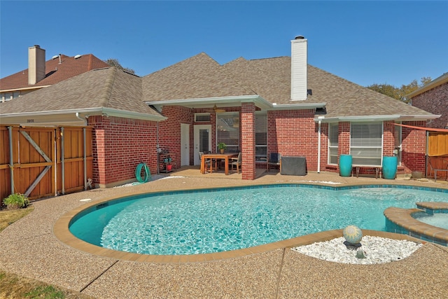 view of pool featuring a gate, a patio, a pool with connected hot tub, and fence