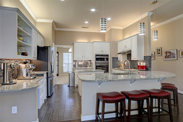 kitchen with visible vents, stainless steel double oven, a peninsula, a sink, and under cabinet range hood