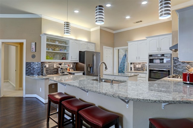 kitchen with visible vents, a sink, light stone counters, stainless steel appliances, and crown molding