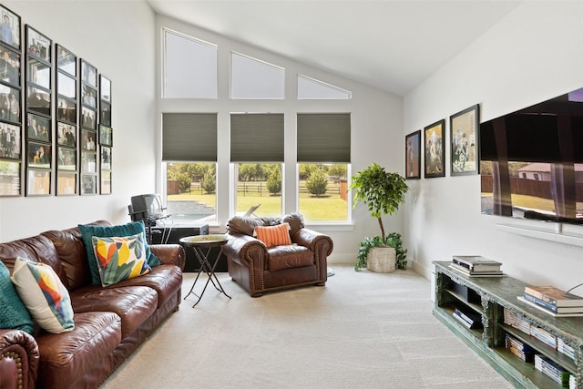 living area with high vaulted ceiling, a wealth of natural light, and carpet floors