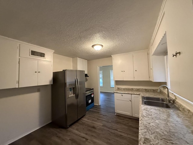 kitchen with a sink, stainless steel appliances, white cabinets, light countertops, and dark wood-style flooring