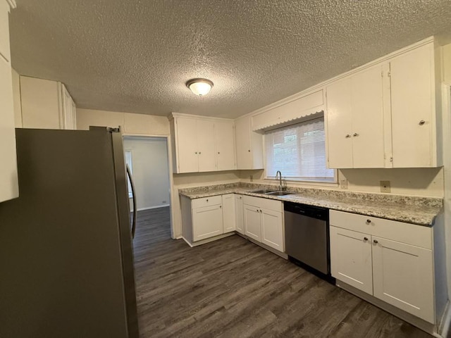 kitchen with light countertops, appliances with stainless steel finishes, dark wood-style floors, white cabinets, and a sink