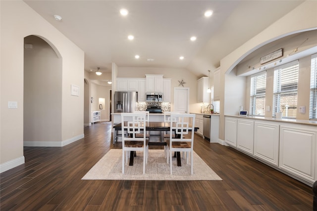 dining area featuring dark wood finished floors, recessed lighting, baseboards, and arched walkways