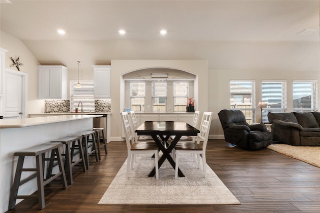 dining room featuring dark wood-type flooring, recessed lighting, and vaulted ceiling