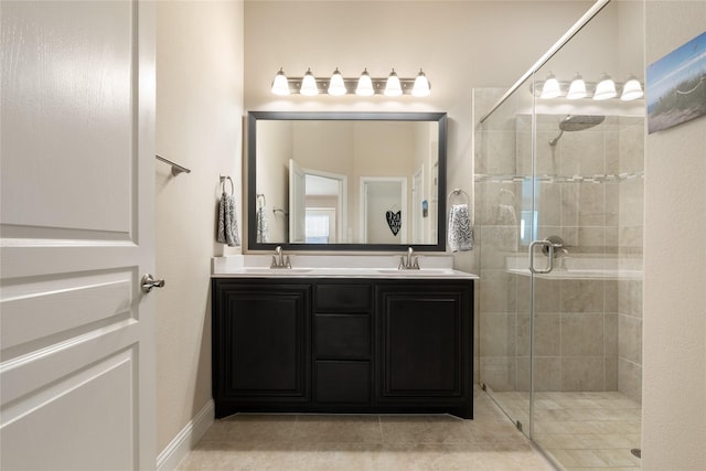 bathroom featuring a sink, a stall shower, double vanity, and tile patterned floors