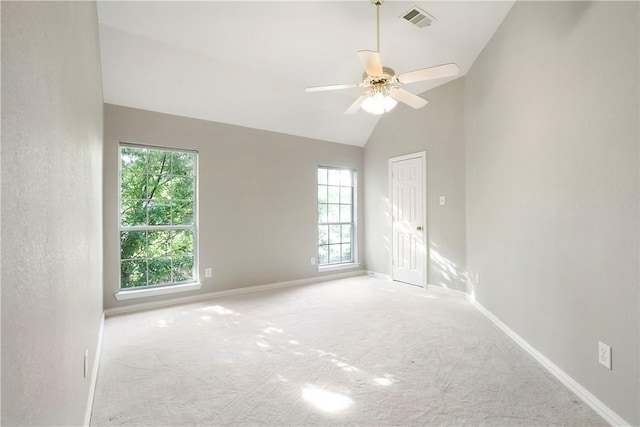 empty room featuring visible vents, lofted ceiling, carpet, baseboards, and ceiling fan