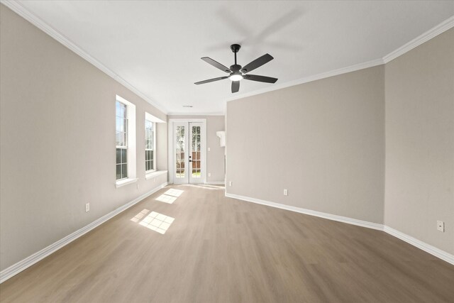 unfurnished room featuring french doors, baseboards, wood finished floors, and ornamental molding