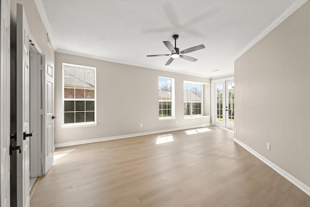 spare room with crown molding, light wood-style flooring, french doors, and baseboards