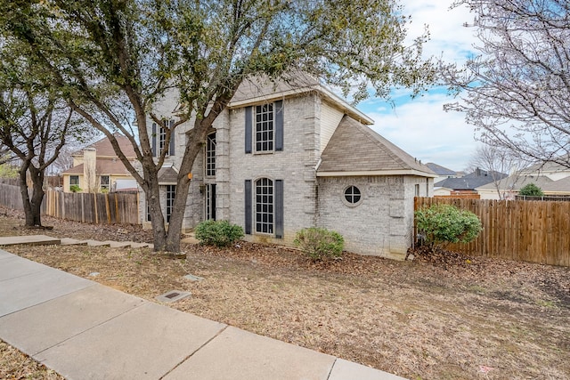 view of front of property featuring brick siding and fence