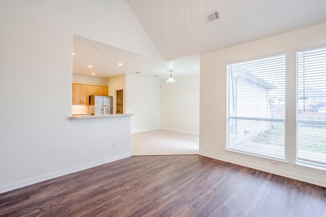 unfurnished living room with visible vents, wood finished floors, recessed lighting, baseboards, and lofted ceiling