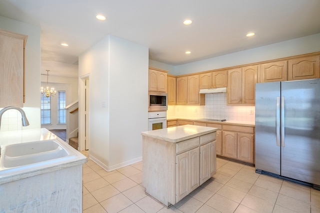 kitchen featuring light brown cabinets, appliances with stainless steel finishes, under cabinet range hood, and a sink