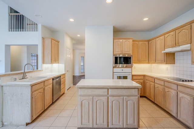 kitchen with under cabinet range hood, stainless steel appliances, light tile patterned flooring, and light brown cabinetry