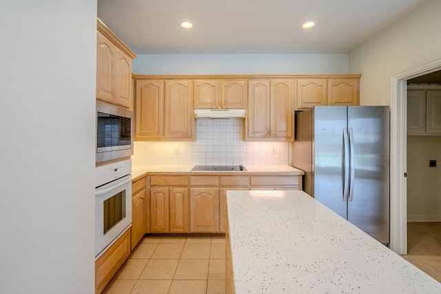 kitchen featuring under cabinet range hood, light brown cabinets, appliances with stainless steel finishes, and light countertops