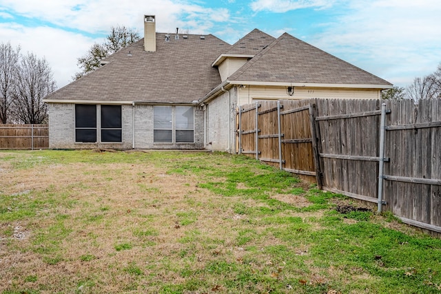 975 W Corporate Dr, Lewisville, TX 75067 - back of property with a fenced backyard, brick siding, a shingled roof, a yard, and a chimney