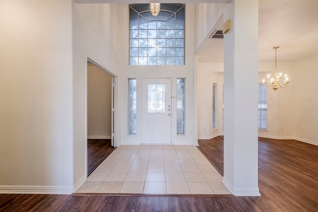 entryway with a notable chandelier, wood finished floors, and baseboards