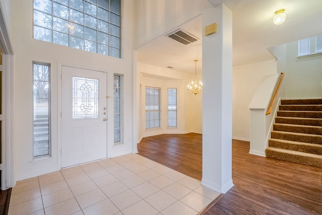 975 W Corporate Dr, Lewisville, TX 75067 - foyer with stairway, wood finished floors, visible vents, ornamental molding, and an inviting chandelier