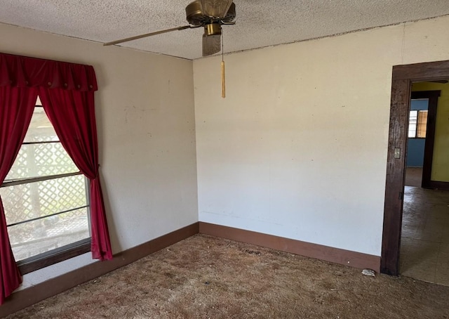 unfurnished room with ceiling fan, baseboards, and a textured ceiling