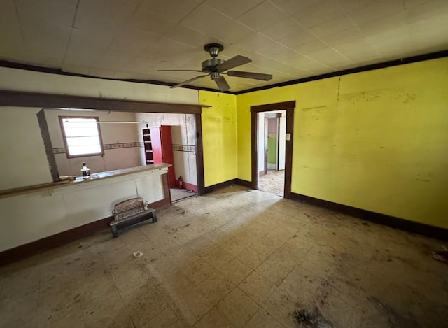 interior space with tile patterned floors, a ceiling fan, and baseboards