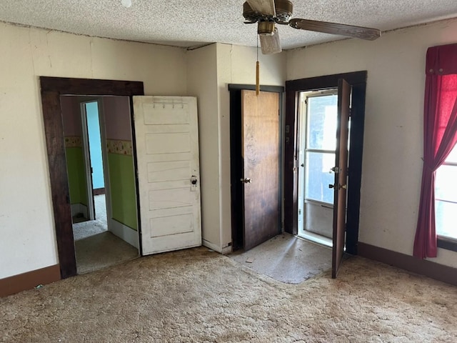 unfurnished bedroom with multiple windows, a textured ceiling, and carpet