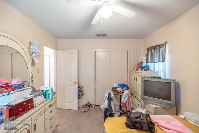 bedroom featuring visible vents, light colored carpet, a closet, and ceiling fan